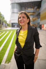 Portrait of happy mature businesswoman smiling outdoors