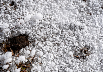 Hail and snow on frozen ground
