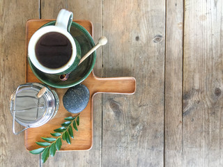 Flat lay of a set of coffee cup and sugar container on wooden tray on wooden table in a cafe 