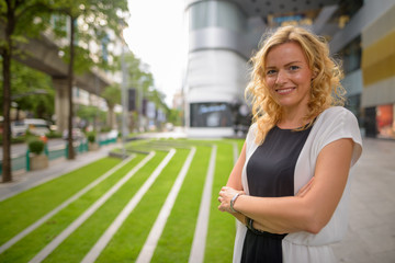 Portrait of beautiful blonde businesswoman smiling outdoors