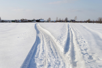 Fototapeta na wymiar Winter landscape with small village, tracks in snow