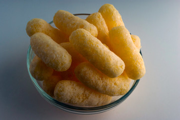 Corn Puffs in a Glass Bowl. Crunchy Flavored Puffed Snacks. Party, Movie Snacks.