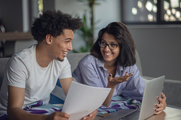 Worried young couple discussing bills at home