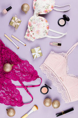 Different sets of lace lingerie, presents and Christmas decoration on pastel background. Woman fashion Christmas concept