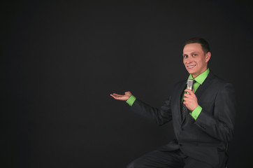 The leading show or businessman with microphone in the hands is showing on a copy space isolated on...
