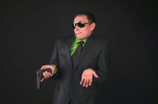 The guilty security agent with a gun apologizes for the misunderstanding during the inspection isolated on black background.