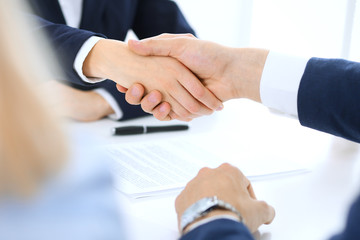 Group of business people or lawyers shaking hands finishing up a meeting , close-up. Success at negotiation and handshake concepts