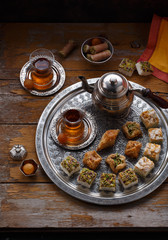 Assorted oriental sweets with tea in traditional cups, copy space