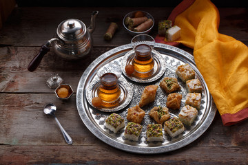 Oriental sweets and tea, copy space, dark photo.