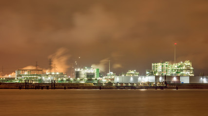 Fototapeta na wymiar Harbor area with Illuminated petrochemical production plant, Port of Antwerp, Belgium.
