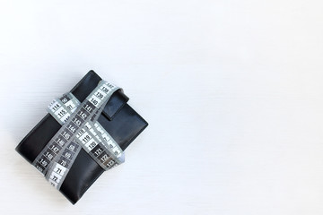 black wallet is wrapped in a white flexible line limiting cash expenditure