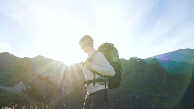 Hiker woman with backpack walking the edge of the canyon at sunset. Enjoying nature vacation travel adventure at Caucasus mountains. Slow motion.