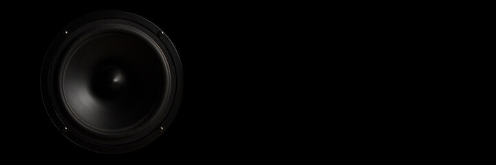 Black Music speaker on a black isolated background. Concept of party or listening to music. Banner