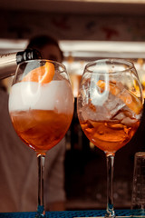 glasses of cocktails on the bar. bartender pours a glass of sparkling wine with Aperol.