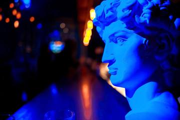 Statues in red and blue in the dark.