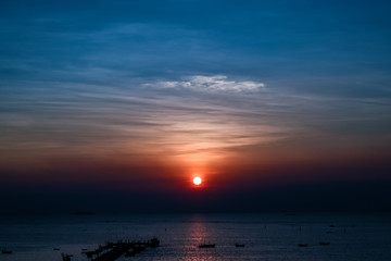 Sunset at the bridge by the sea with a boat surrounded.