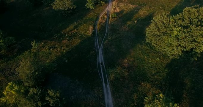 Aerial mtb. MTB bike cycling riding from drone.Senior man riding mountain bike.Aerial: man cycling along country road.Drone flying above cyclist ride on gravel road. Drone cyclocross and mtb riding.