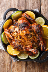 Delicious baked chicken in a spicy citrus marinade close-up in a frying pan. Vertical top view