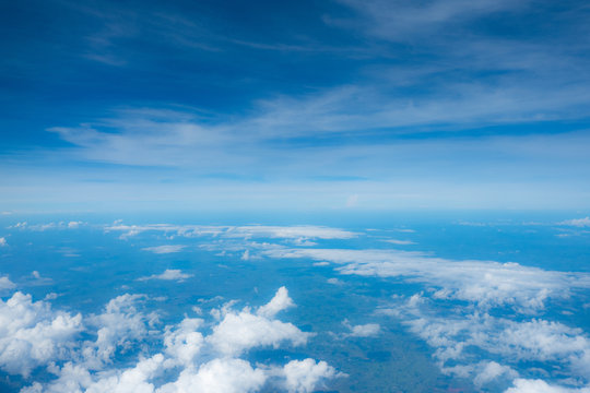 Clouds seen from an airplane, blue sunshine, soil background nature landscape © Zinsmute