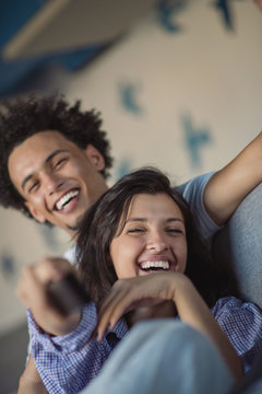 Young black couple relaxing on couch and smiling at camera