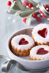Obraz na płótnie Canvas Close-up on traditional Christmas Linzer jam cookies on white table with Xmas decorations