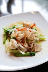 Thai style spicy salad with shrimp and vegetable in white plate. Selective focus.