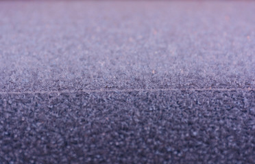 Frost patterns on dark surface. Abstract icy festive background. Close-up. Soft focus