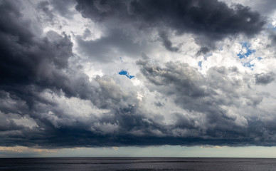 Dark clouds of storm cover all area of sea surface at Nice, France before sunset.