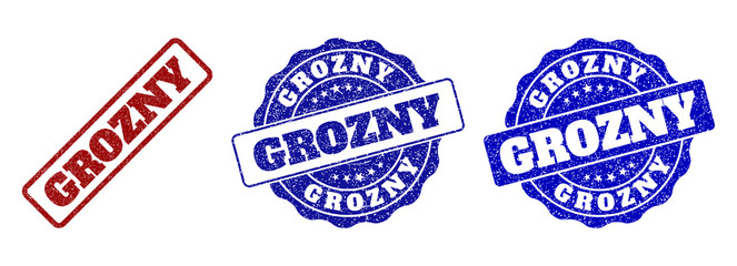 GROZNY scratched stamp seals in red and blue colors. Vector GROZNY labels with scratced effect. Graphic elements are rounded rectangles, rosettes, circles and text labels.