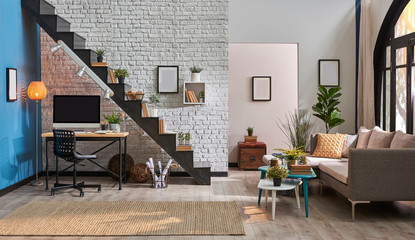 modern living room, grey sofa, wooden desk and desktop, black stairs and white brick wall concept. Frame book and room ornament style.