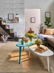 Modern living room middle table white brick wall and black stairs. Frame on the wall.