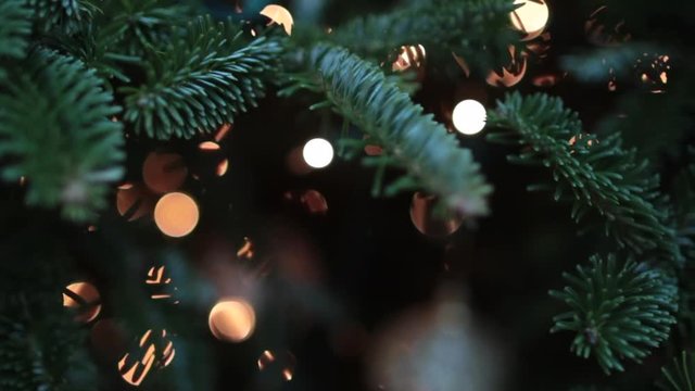 Close up christmas bulbs and lights on tree 