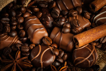 Assortment of white, dark, and milk chocolate. Chocolate with cream, nuts, almonds, hazelnuts and cinnamon with coffee beans. Sweet food and no diet concept.