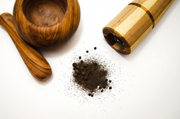 wooden mortar and mill for grinding different spices on light background