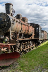Steam locomotive standing on some old railroad track in sunshine