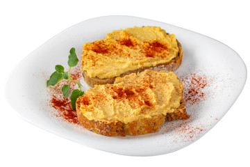 Two open sandwiches with hummus and paprika powder on plate