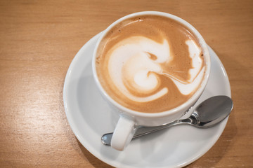 Hot coffee latte on a wooden table.
