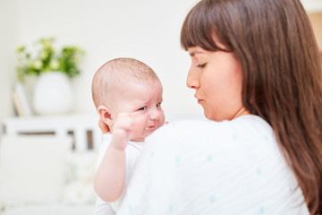 Liebevolle Mutter tröstet ihr kleines Baby