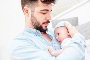 Fototapeta premium Liebevoller Vater mit Baby in den Armen