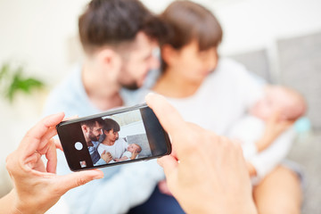 Smartphone macht Bild von Eltern und Baby - obrazy, fototapety, plakaty