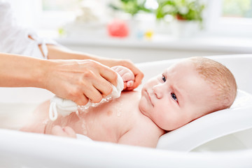 Neugeborenes Baby wird fürsorglich gewaschen