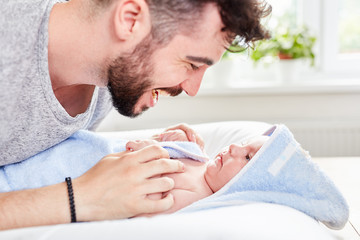 Vater und Baby in Handtuch gewickelt