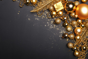 Christmas composition of golden Christmas toys and decoration elements on a black background.