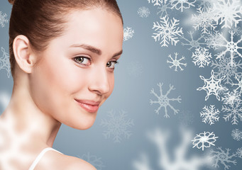 Young woman over blue backgroud with snowflakes.