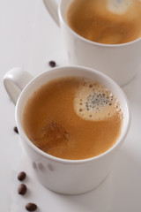 two white cups of coffee on white marble