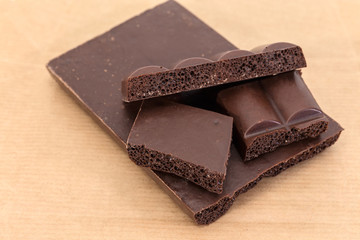 Splitted up block of the dark aerated chocolate close-up