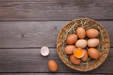Fresh Chicken eggs in basket on grey wooden background