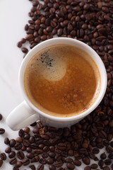 Naklejka premium cup of black coffee closeup of coffee beans top view.