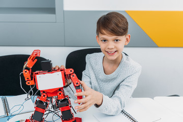 schoolboy working with robot at STEM robotics lesson