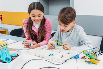 schoolchildren working on robot at STEM robotics lesson